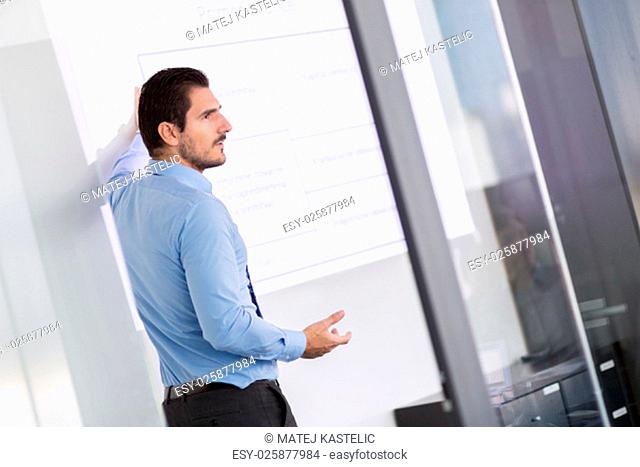 Business man making a presentation in front of whiteboard. Business executive delivering a presentation to his colleagues during meeting or in-house business...