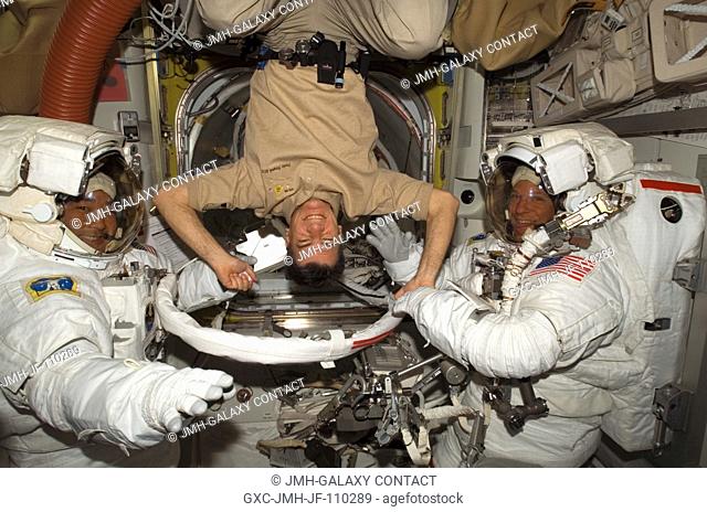 European Space Agency (ESA) astronaut Paolo Nespoli (center), STS-120 mission specialist, turns a flip for astronauts Scott Parazynski (right)