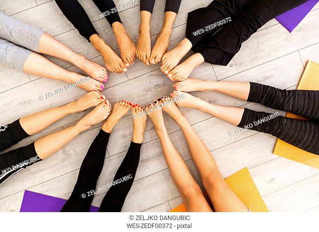 Legs of women in yoga class sitting together in circle