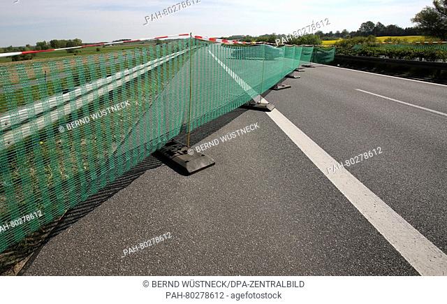 A game fence stretches along the A20 motorway between Sanitz and Dummerstorf, Germany, 11 May 2016. Licensed hunters and staff of the road maintenance authority...