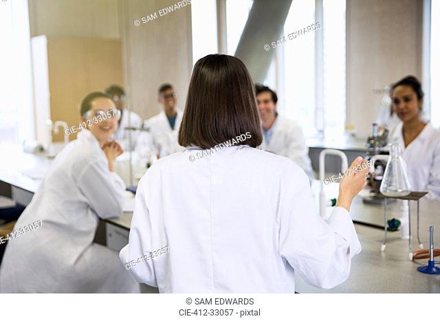 Female college student leading study group in science laboratory classroom