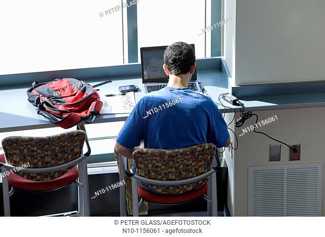 College student working on his laptop computer