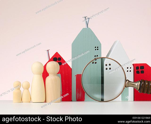 Magnifier and wooden house on a brown background. Real estate rental, purchase and sale concept. Realtor services, building repair and maintenance