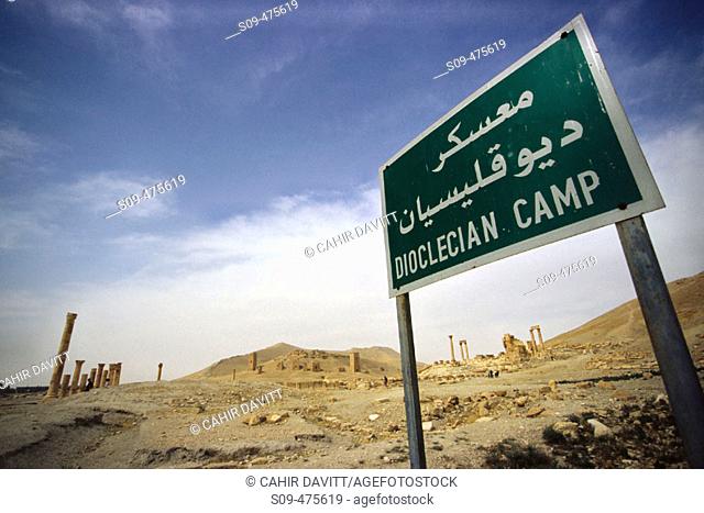Sign post on the Transverse Street marking the extent of the Dioclecian Camp in the ruins of Palmyra, Syria.  The Funery Tower Tomps of Iamliku can be seen in...