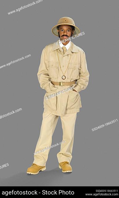 Full length portrait of a boy dressed up as archaeologist mummy hunter for Halloween, against a gray background