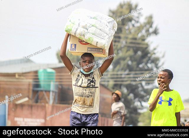 Children carry food items for resale in Chitungwiza, Zimbabwe. Majority of Zimbabweans survive selling different products for survival. Zimbabwe