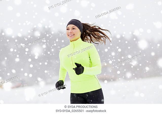 happy woman running along snow covered winter road