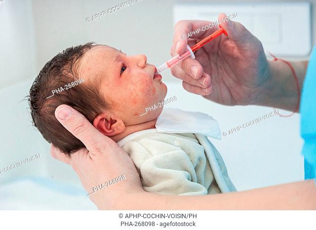 Pediatric nurse giving a newborn baby vitamine D