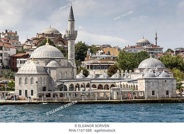 Couple walking past the Semsi Pasa Mosque, seen from the Bosphorus Strait, Uskudar, Istanbul, Turkey, Europe