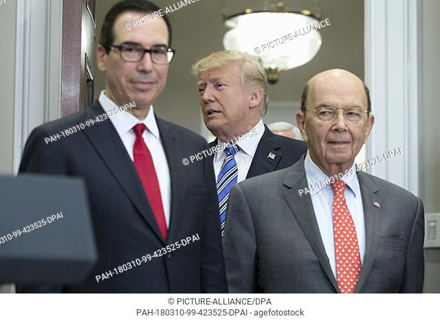 US President Donald J. Trump (C) enters behind US Treasury Secretary Steven Mnuchin (L) and US Commerce Secretary Wilbur Ross (R)