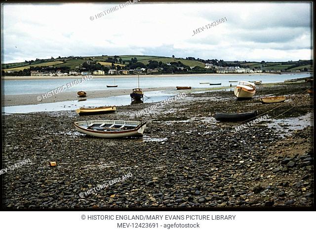 A view across the River Torridge of Instow, from the base of the slipway at the north of The Quay, with small boats beached in the foreground