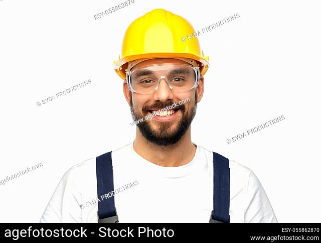 happy male worker or builder in helmet and overall