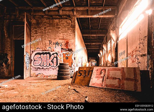 An old abandoned industrial area, with lots of graffiti that is slowly falling apart