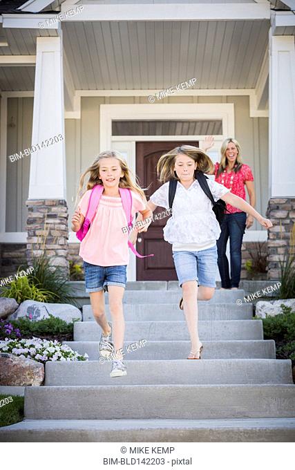Caucasian mother sending running sisters to school