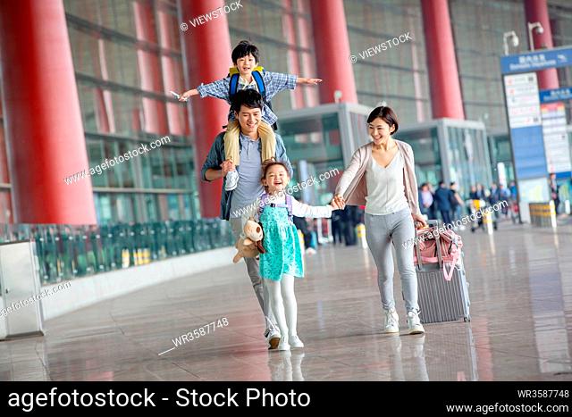 A happy family with luggage at the airport