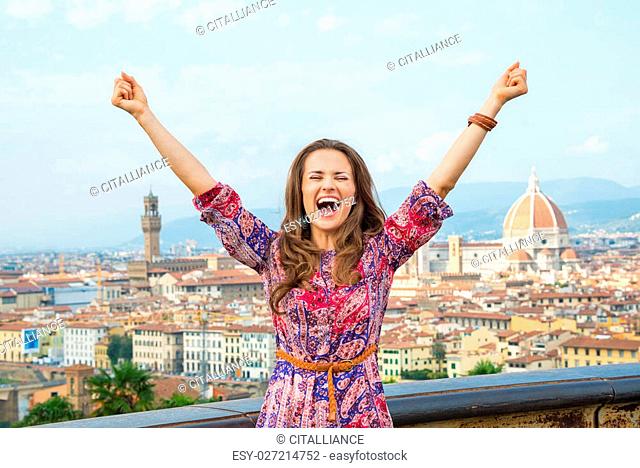 Happy young woman rejoicing against panoramic view of florence, italy