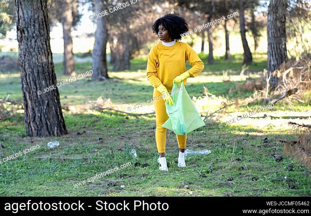 Young woman collecting garbage in park