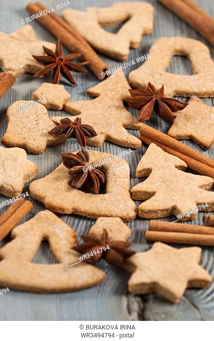 Gingerbread cookies and spices over wooden background