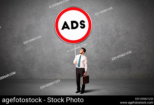 Young business person holdig traffic sign with ADS abbreviation, technology solution concept