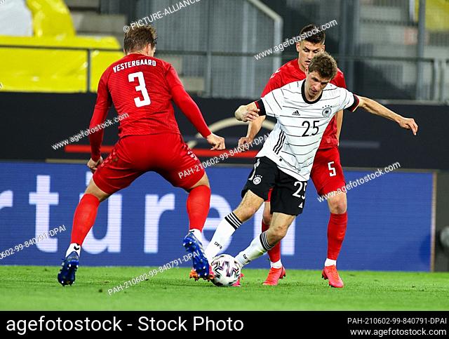 02 June 2021, Austria, Innsbruck: Football: International match, Germany - Denmark at Tivoli Stadium. Thomas Müller (M) of Germany and Jannik Vestergaard (l)...