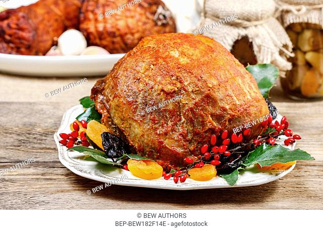 Baked pork with fruits on wooden table