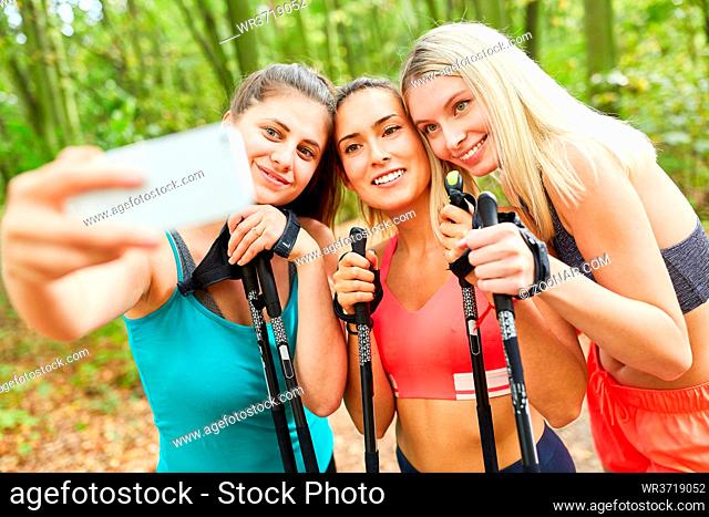 Drei junge Frauen als Freundinnen machen ein Selfie beim Nordic Walking