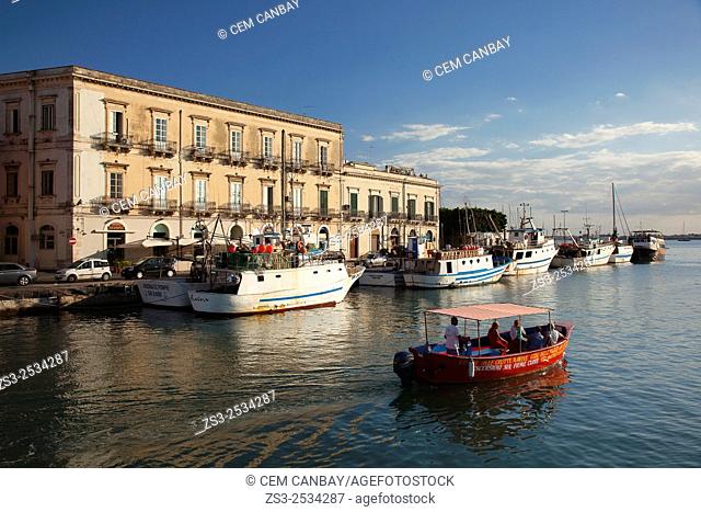 Red Cruise boat in front of the Venezian style buildings in Ortigia Island, Syracuse, Sicily, Italy, Europe