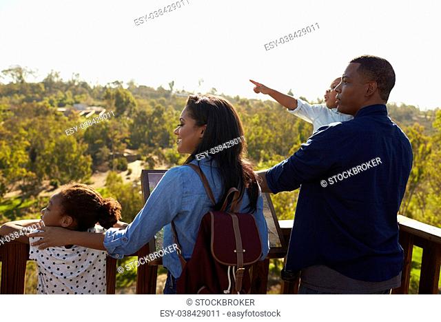 Family Standing On Outdoor Observation Deck Looking At View