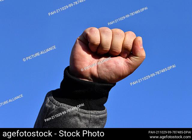 29 October 2021, Thuringia, Eisenach: A man clenches his fist at a demonstration not far from the Opel plant in Eisenach