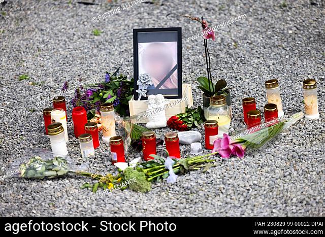 29 August 2023, North Rhine-Westphalia, Süsterseel: Flowers, candles and a photo showing Dorota G. stand in front of the house where she lived with her husband