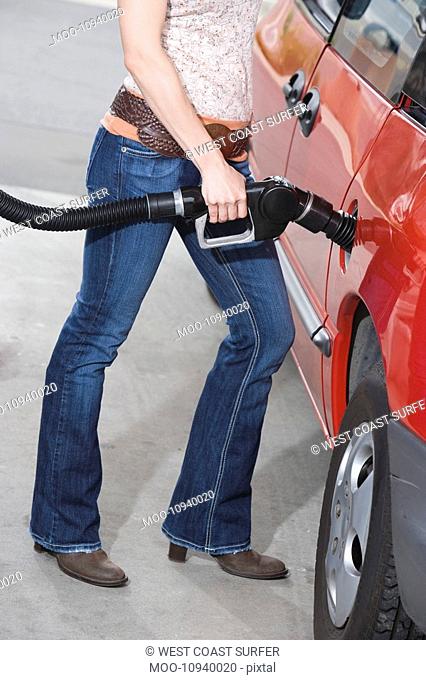 Woman by car with fuel pump