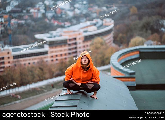 Young woman practicing yoga on the roof and doing yoga exercises