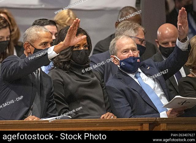 Former United States President Barack Obama, former first lady Michelle Obama, and former US President George W. Bush wave as they await the start of the...