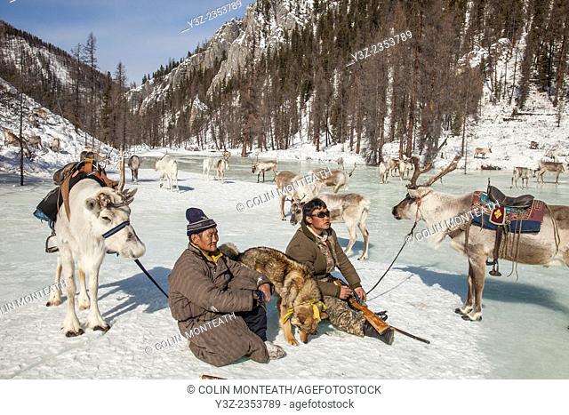 Tsataan reindeer herders rest on frozen lake , Hunkher mountains, northern Mongolia