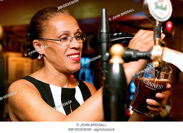 Woman working behind a bar in a pub