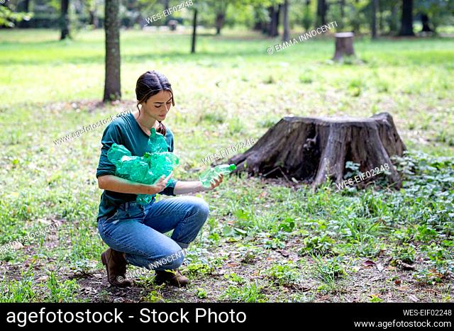 Woman collecting plastic bottles in park