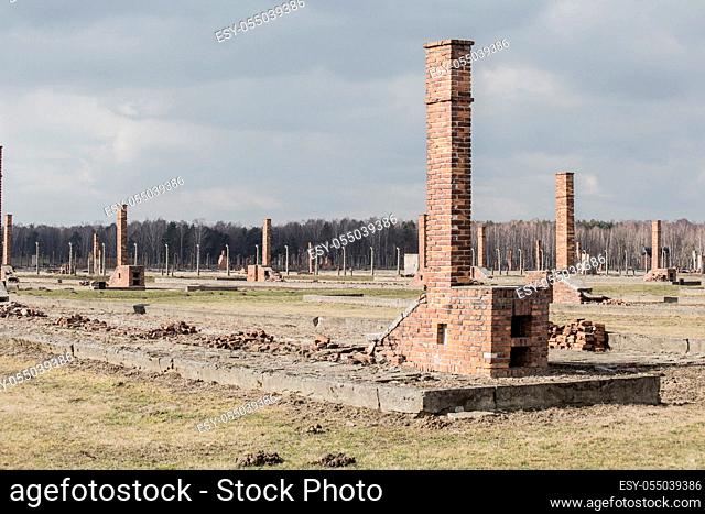 Auschwitz II Birkenau, ruins of barracks at Birkenau. Stoves and chimneys are all that remains of old wooden concentration camp barracks March 12, 2019 war