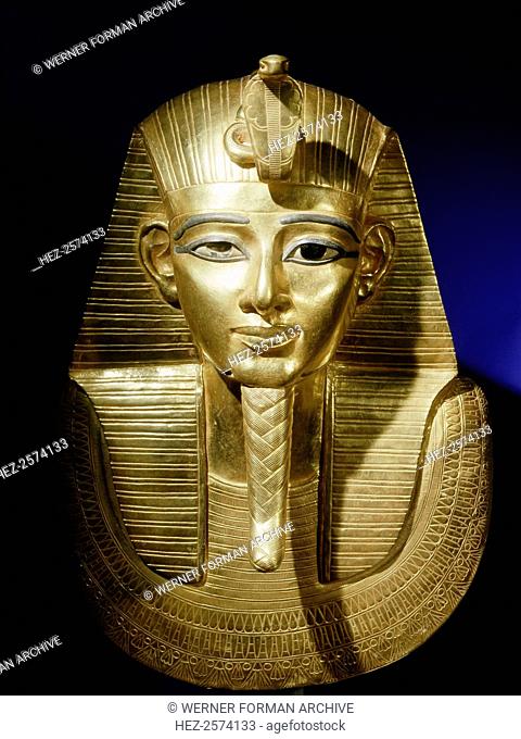 Gold funerary mask from the burial of Psusennes I. The king is shown as a young man, wearing the royal headcloth, secured by a uraeus or cobra