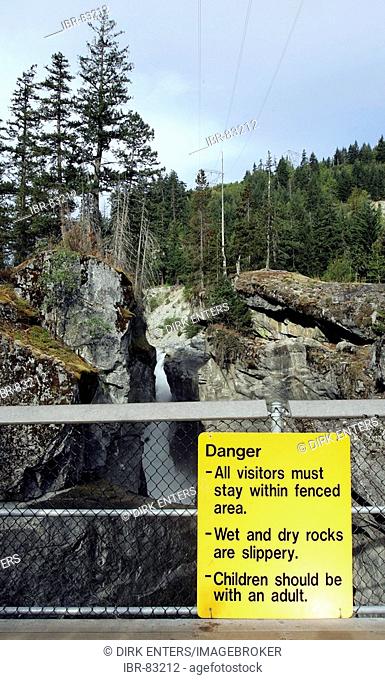 Yellow danger sign at Nairn Falls - Green River in British Columbia, Canda