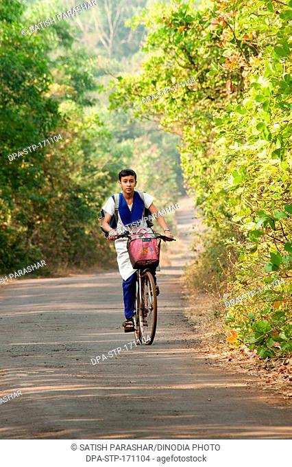 Young girl going school on bicycle in ; Lanja ; Ratnagiri ; Maharashtra ; India MR556