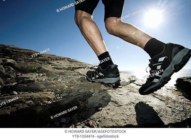 Man running along a rocky coastal path