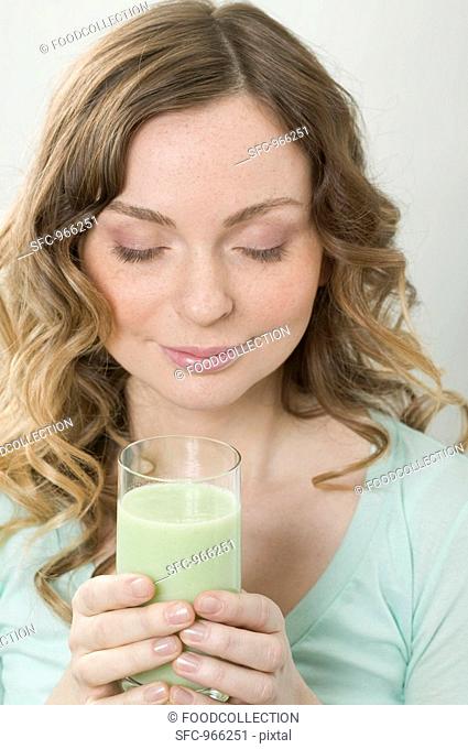 Woman holding glass of cucumber shake