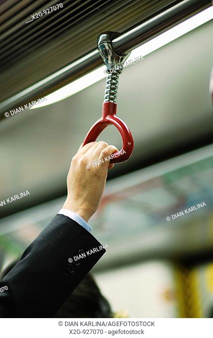 A hand of a businessman inside MTR in Hong Kong, HKSAR