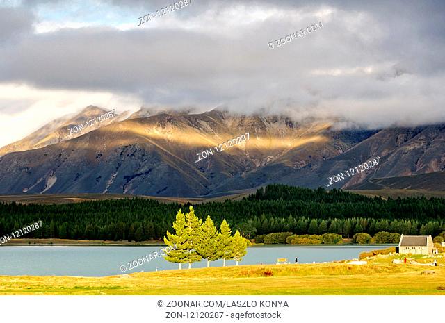 Sun breaking through the clouds over Lake Tekapo and the Church of the Good Sheppard on the South Island of New Zealand