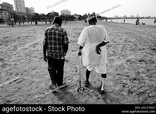 Paralysed man, stroke patient, walking on beach, Chowpatty, Girgaon, Bombay, Mumbai, Maharashtra, India, Asia