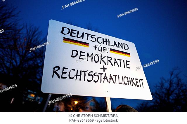 A sign reading 'Deutschland für Demokratie + Rechtsstaatlichkeit' (lit. 'Germany for democracy and constitutional legality') is held up during a demonstration...