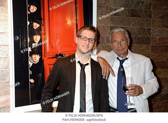 French photographer Jean-Marie Perier (R) and gallery owner Emeric Descroix pose together in front of a photograph titled 'les Beatles' from 1964