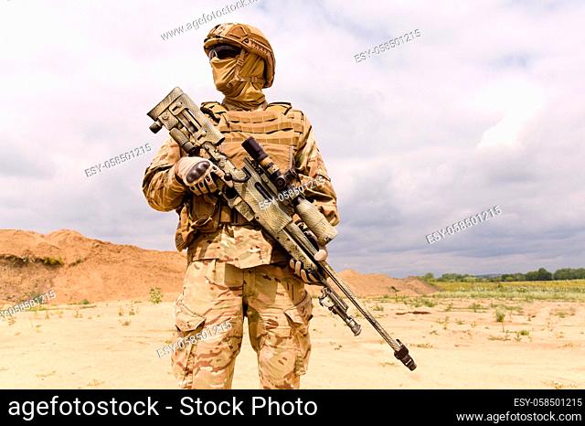 Fully equipped and armed special forces soldier with sniper rifle close-up