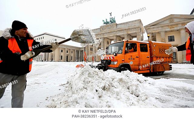 Employees of the Berlin cleansing department clear snow in front of the Brandeburg Gate in in Berlin, Germany, 19 March 2013