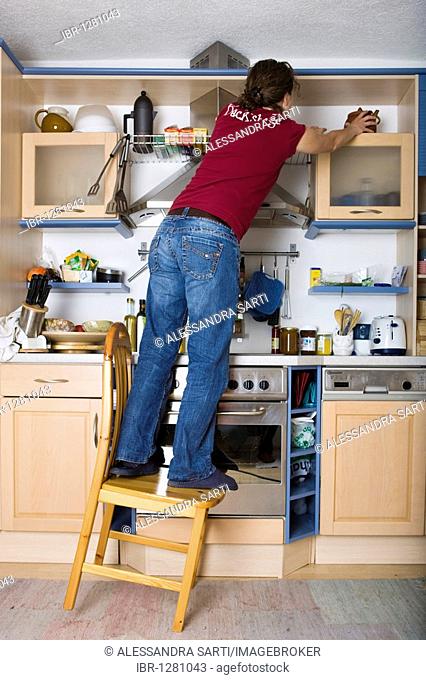 Household accidents, girl standing on a chair in the kitchen, tilting